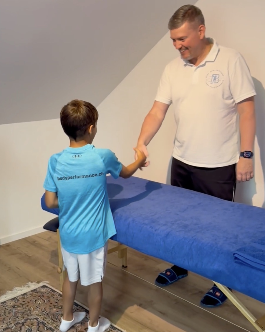 Sascha Göbl begrüsst einen jungen Sportler mit einem Handschlag.